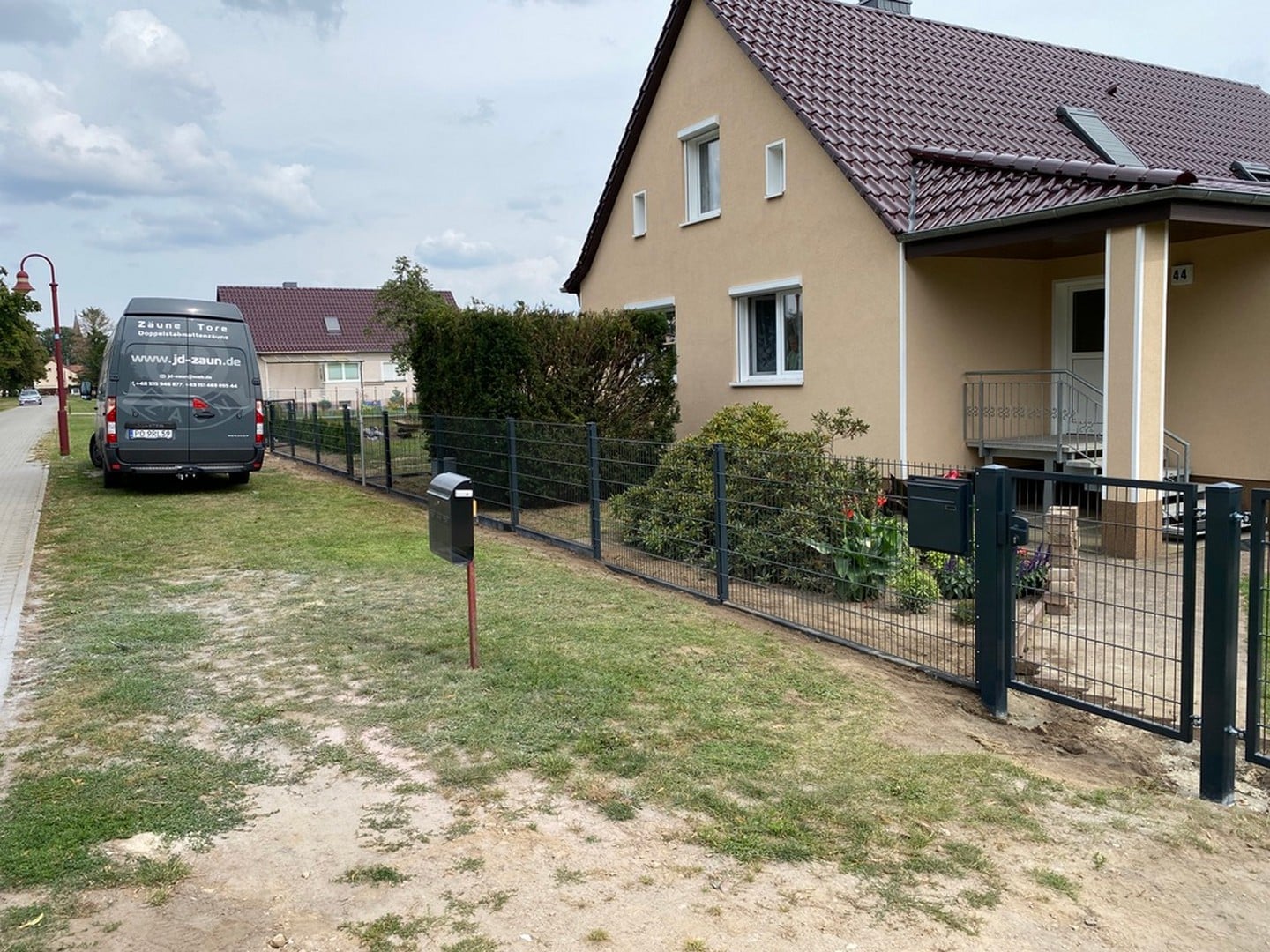 Wohnhaus mit Zaun und Lieferwagen in Deutschland.