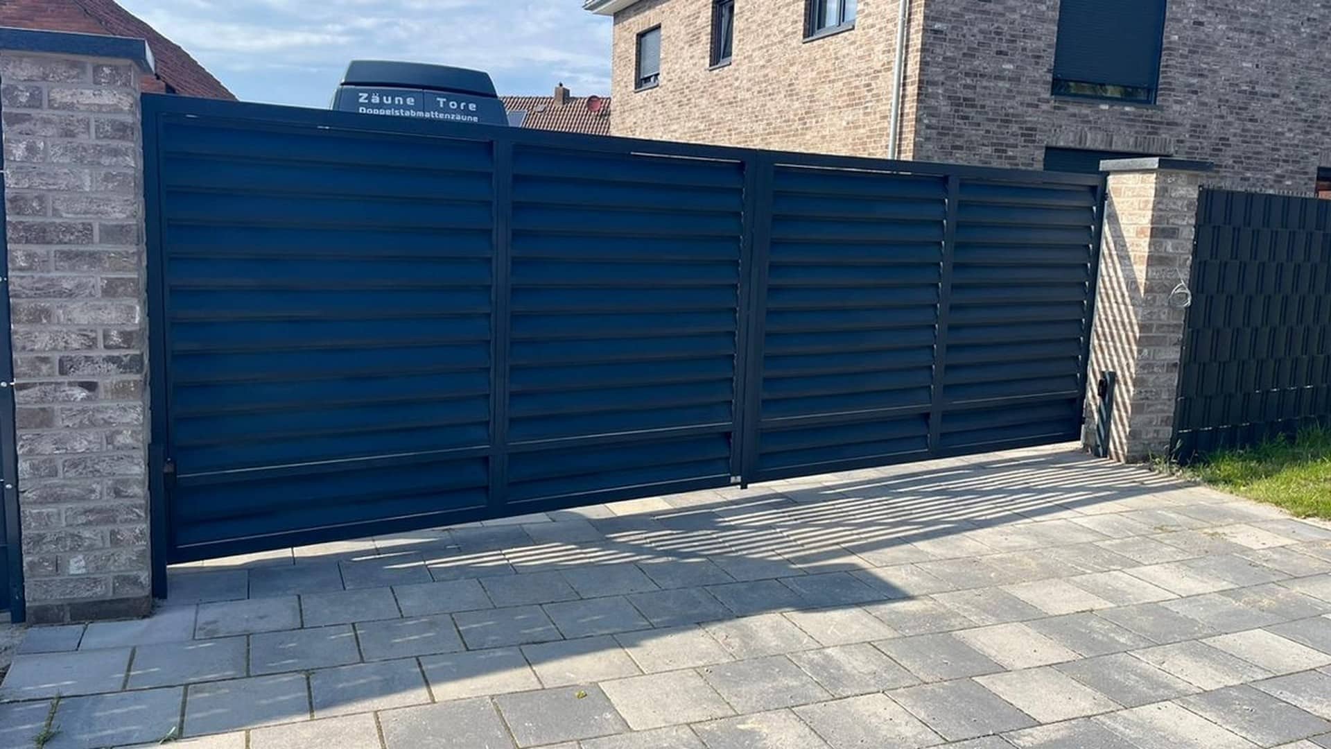 Blaue Gartentür und Zaun aus Metall.