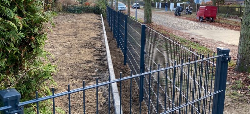 Frisch installierter Doppelstabmattenzaun von JD-Zaun entlang eines Weges neben einem Gartenbereich